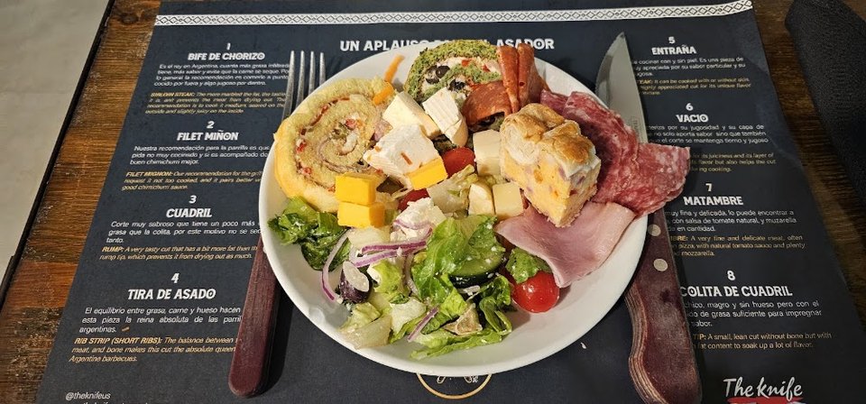 Menu-style spread of meats, salads, and cheese.